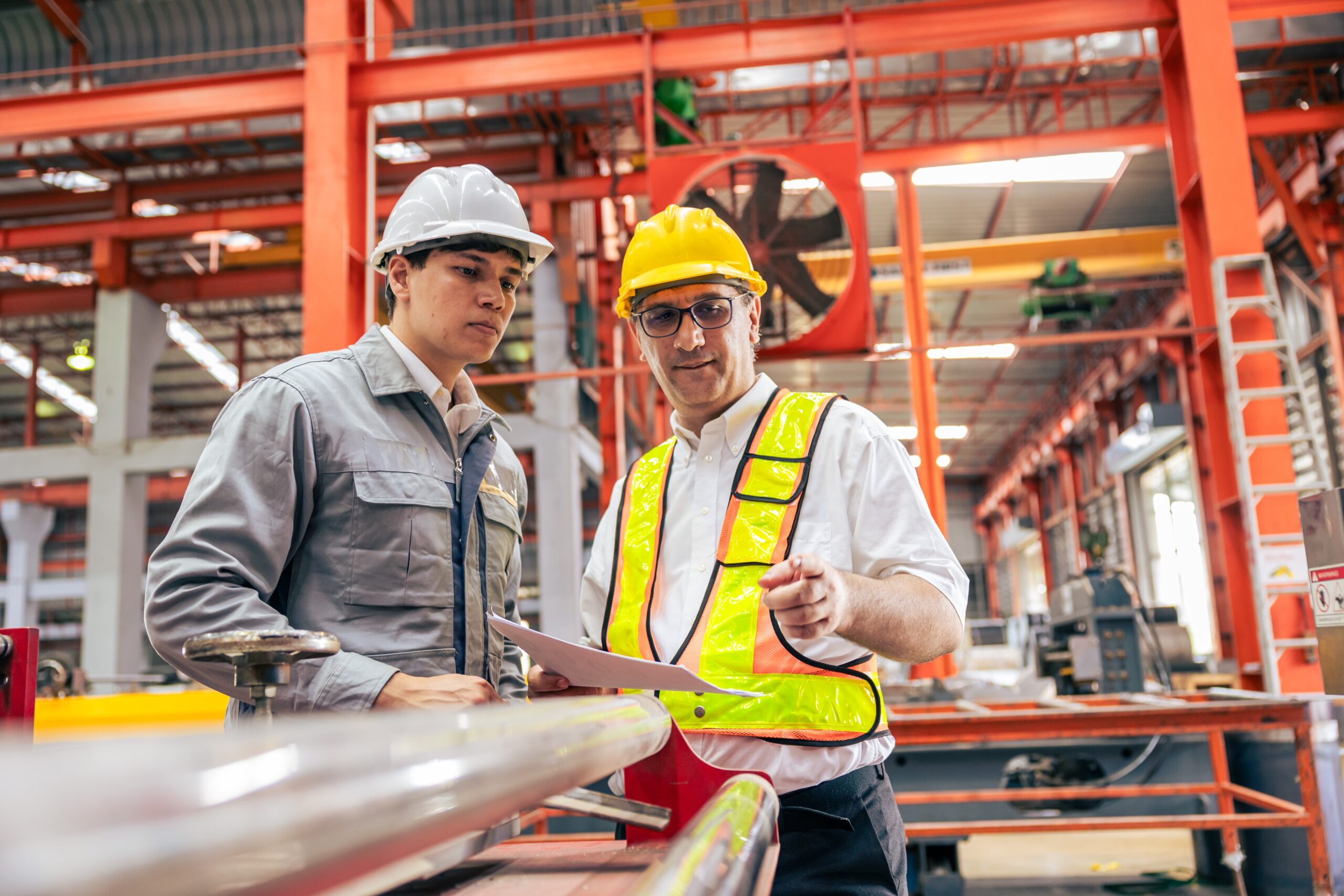 strategic learning design - two people stand together in a warehouse wearing protective construction gear.